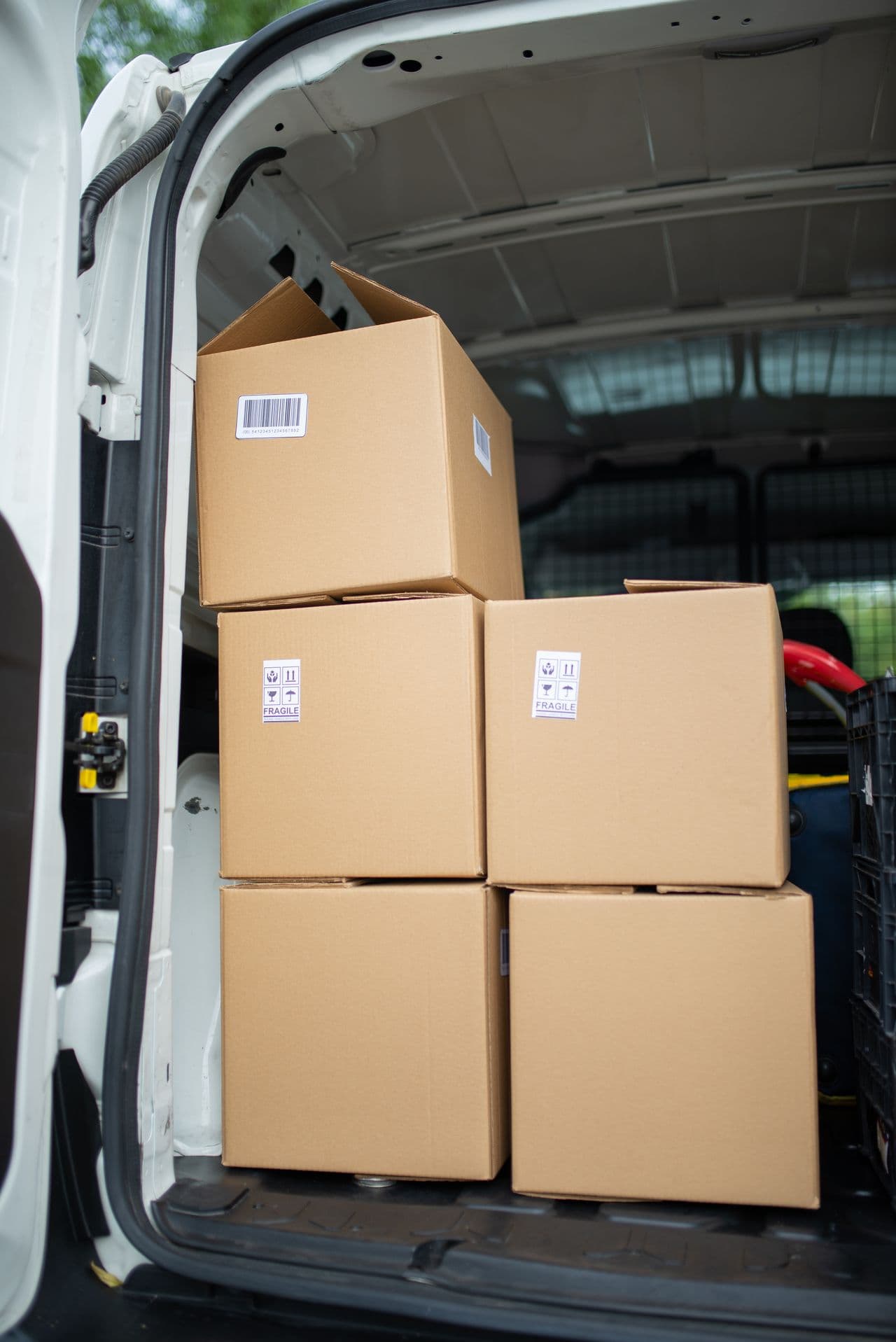 Labeled cardboard boxes stacked inside a delivery van